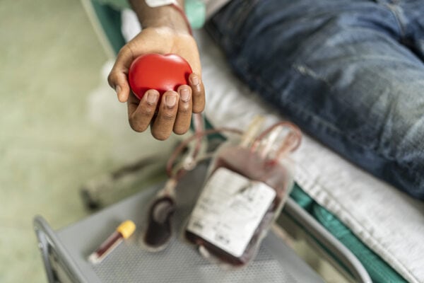 The hand of a blood donor squeezing a medical rubber ball